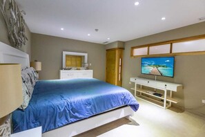 Ein Schlafzimmer mit Bett, Schminktisch, Fernseher und Spiegel.