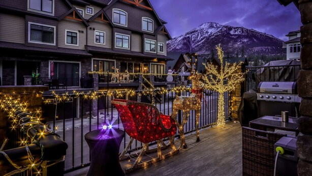 Un hôtel doté d’un balcon, décoré avec un motif de renne, et avec une montagne en arrière-plan.
