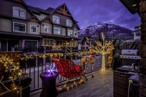 A hotel with a balcony, a reindeer decoration, and a mountain in the background. - ⭐⭐⭐⭐⭐Macaron by Samsara Resort|Private Hot Tub|Private Entry|Panorama Top View|4B+5BH ( BL# RES-10673 ) (Canmore)
