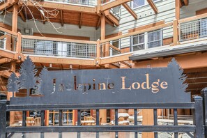 A sign for Jackpine Lodge with a wooden structure and balconies. - Jack Pine 8006 (Keystone)