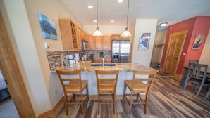 A kitchen with wooden cabinets, a granite countertop, and a stainless steel refrigerator. - Elk Run Villas 9574 (Keystone)