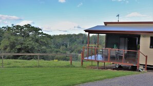 A building with a covered porch and a fenced area.