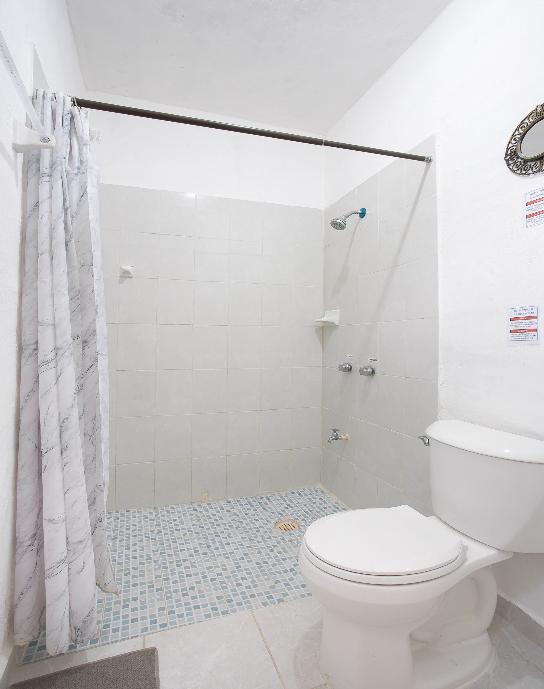 Un bagno con doccia, WC e pavimento piastrellato.