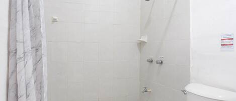 Un bagno con doccia, WC e pavimento piastrellato.