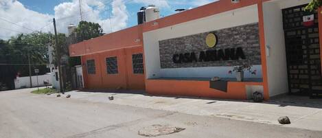 Un edificio con un letrero que dice "CASA ARANA" y fachada de ladrillo.