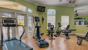 Une salle de sport équipée de tapis de course, de vélos elliptiques et de matériel de musculation.
