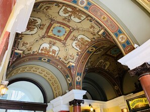 An ornate ceiling with intricate frescoes and architectural details. - Budapest Three Cats Hostel (Budapest)