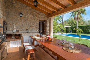 An outdoor dining area with stone walls, wooden beams, and a view of a swimming pool. - FINCA POU NOU - Fantastic villa, with private pool, at only 750 meters from Inca. Free WiF (Inca)