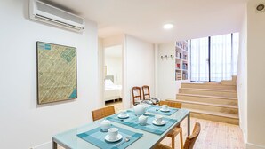 A dining area with a glass table, chairs, and a map on the wall. - Genteel Home Catedral Sevilla (Sevilla)