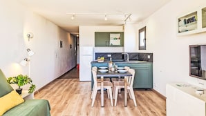 Un appartement moderne comprenant un coin repas, une cuisine et un espace de vie.