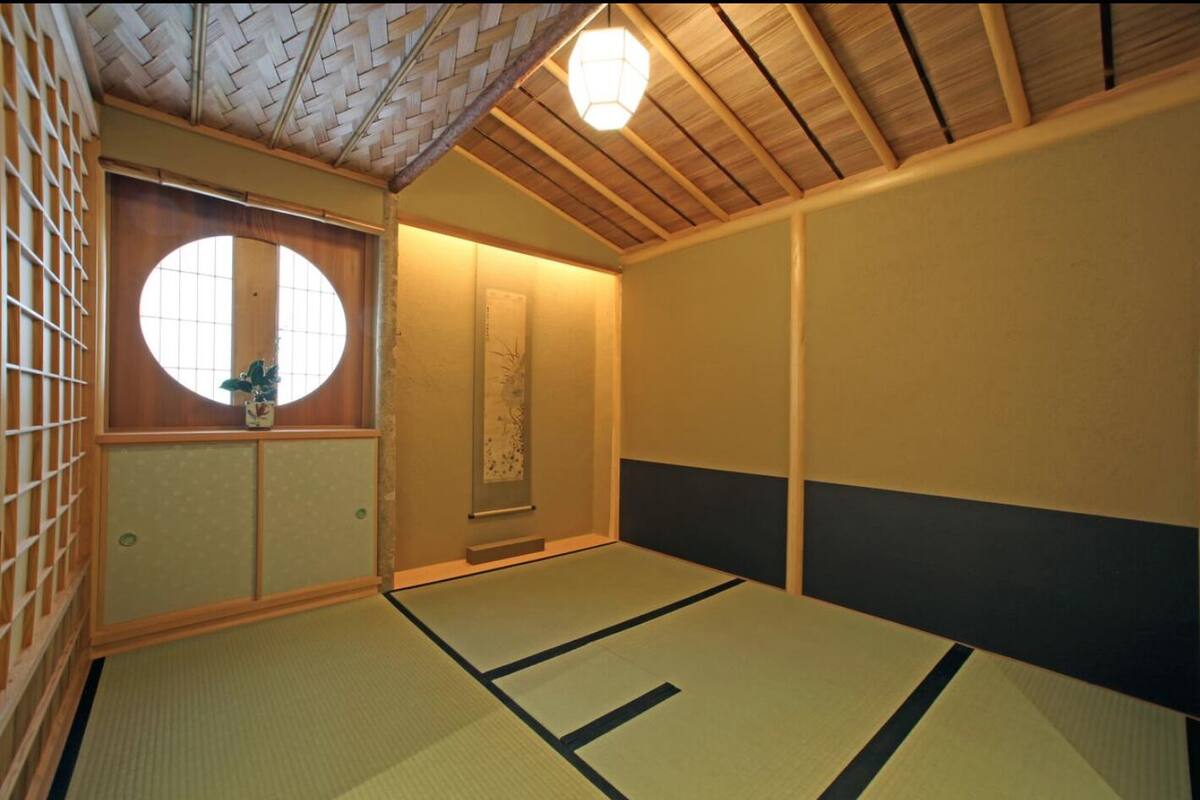 Une pièce de style japonais traditionnel, avec un sol recouvert de tatamis, un paravent shoji et une porte coulissante.