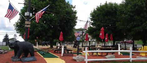 Een park met picknicktafels, een beerbeeld en Amerikaanse vlaggen.