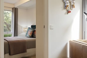Ein Schlafzimmer mit einem Bett, einem Fenster und einer Wanddekoration.