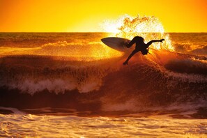 A surfer riding a wave at sunset. - Astera Villa Seminyak by Ini Vie Hospitality (Legian)