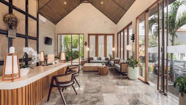 A modern interior with a reception desk, seating area, and large windows. - Astera Villa Seminyak by Ini Vie Hospitality (Legian)