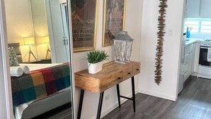 Een moderne keuken met witte kasten, een houten aanrecht en een hangende plant.