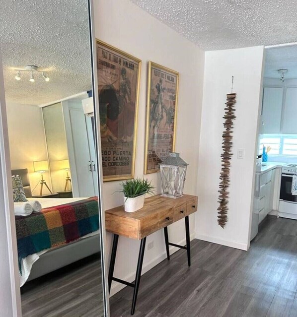 Una cocina moderna con armarios blancos, encimera de madera y una planta colgante.