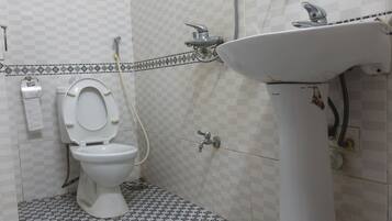 A bathroom with a toilet, a sink, and a shower.