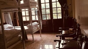 A dormitory room with bunk beds and a seating area with tables and chairs. - Ha Giang Discovery Hostel (Ha Giang 1)