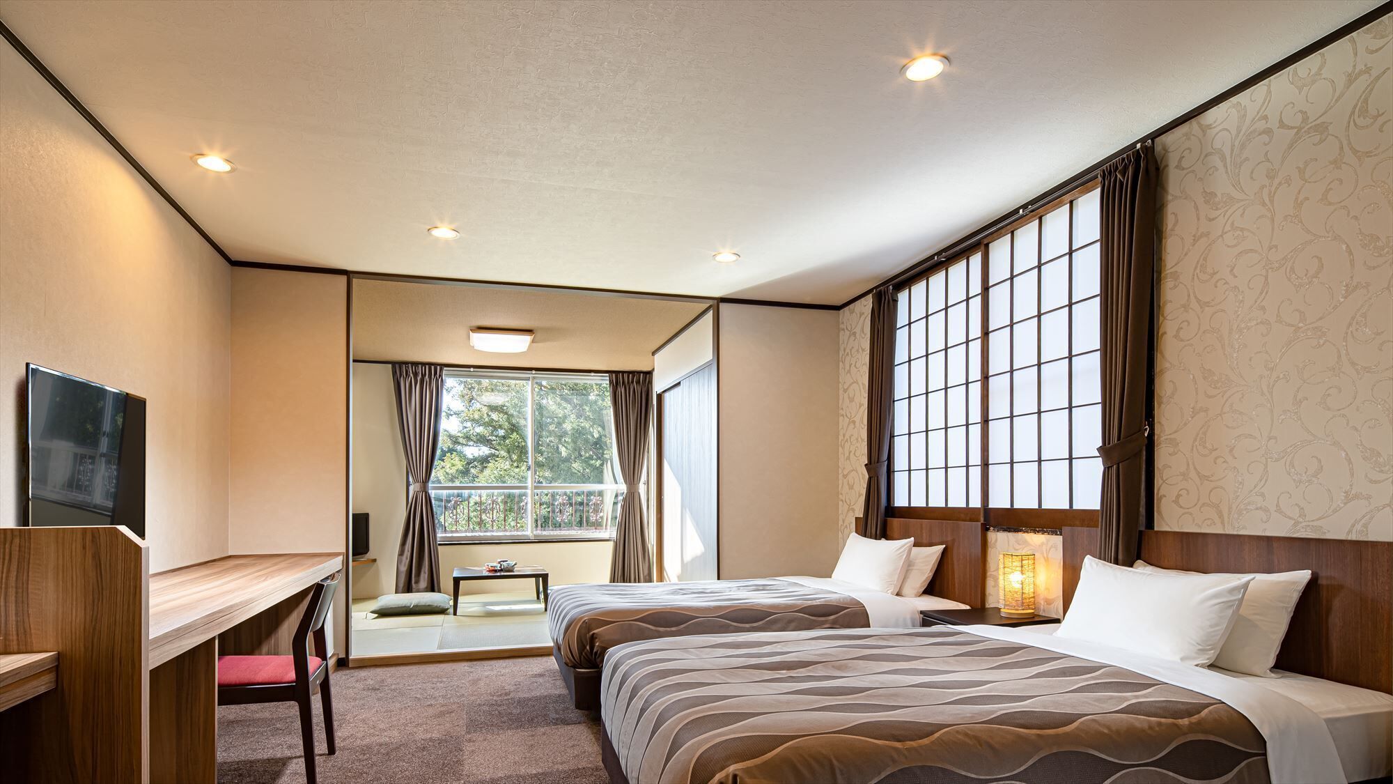A hotel room with two beds, a desk, a TV, and a window with curtains.