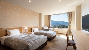 A hotel room with two beds, a desk, a chair, and a large window with a view of mountains. - HESTA Hakone (Hakone)