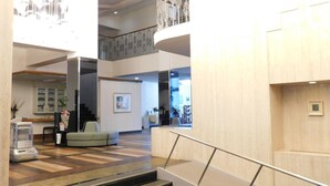 A spacious lobby with a staircase leading to a second floor, a seating area, and a reception desk. - HESTA Hakone (Hakone)