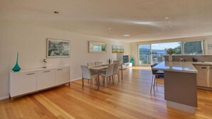 A spacious kitchen with a dining area, large windows, and a view of the outdoors.