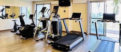A gym with treadmills, stationary bikes, and ellipticals.