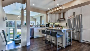 A modern kitchen with a central island, stainless steel appliances, and a view to the outdoors.