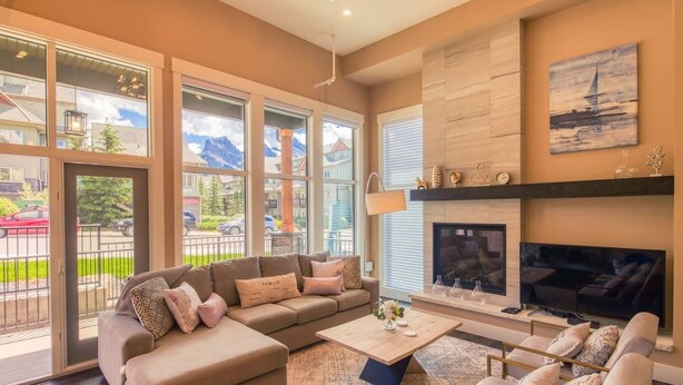 A spacious living room with a large sofa, a coffee table, and a fireplace.