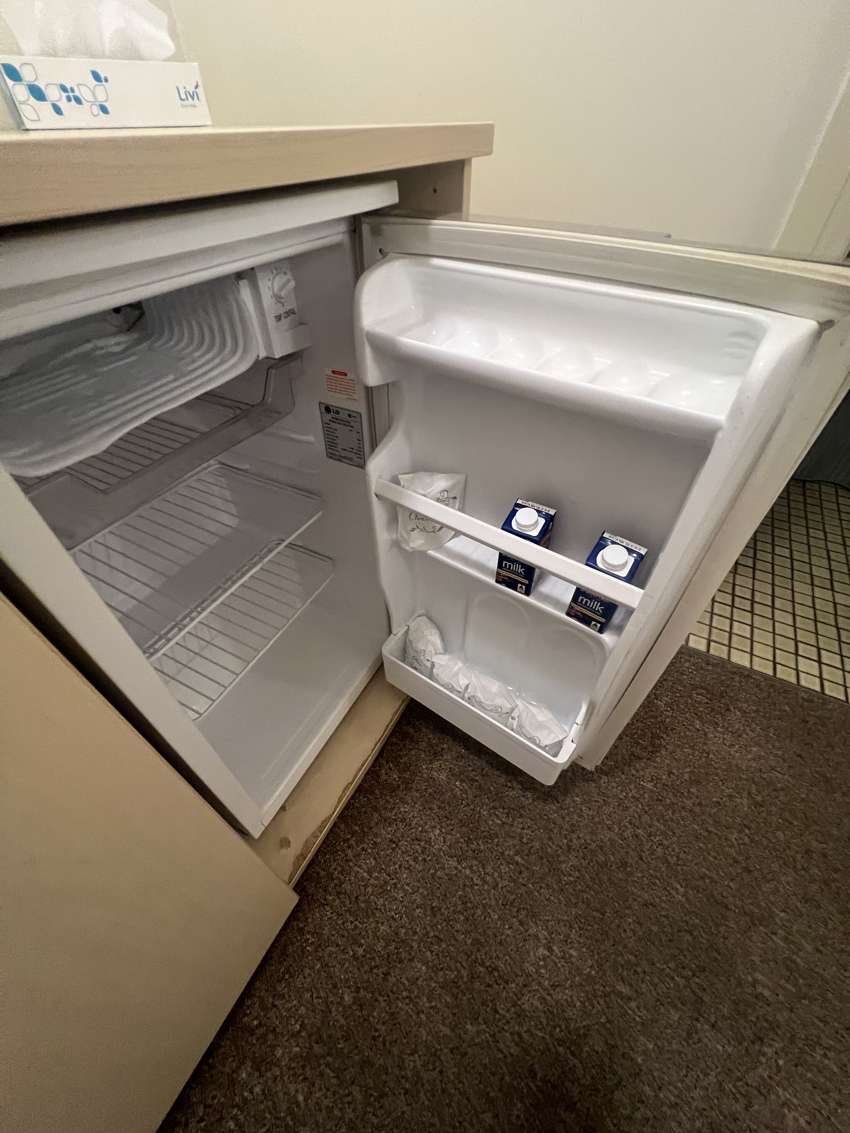 A refrigerator with milk cartons and a carton of juice.