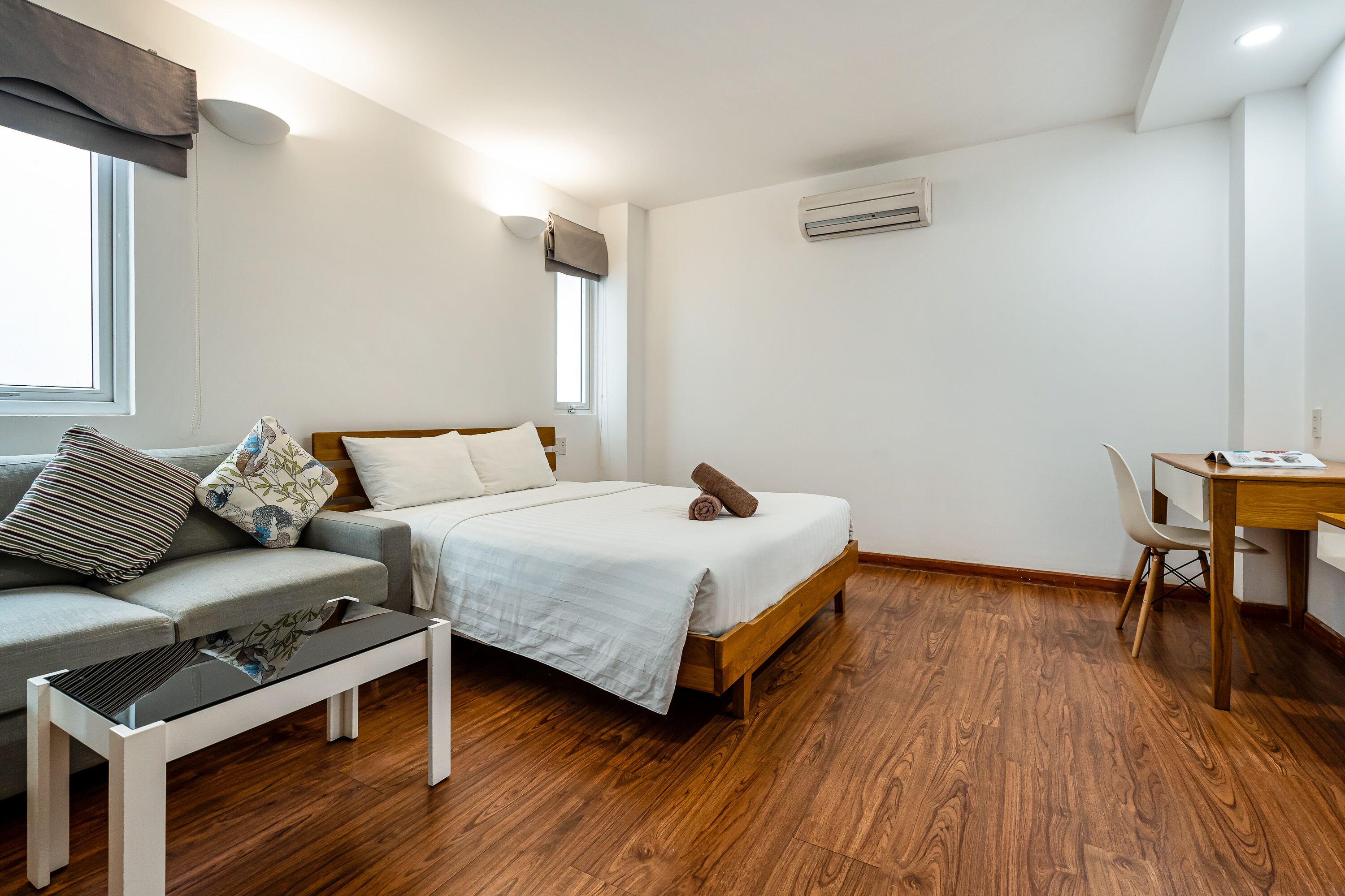 Un dormitorio con cama, sofá, escritorio y silla.