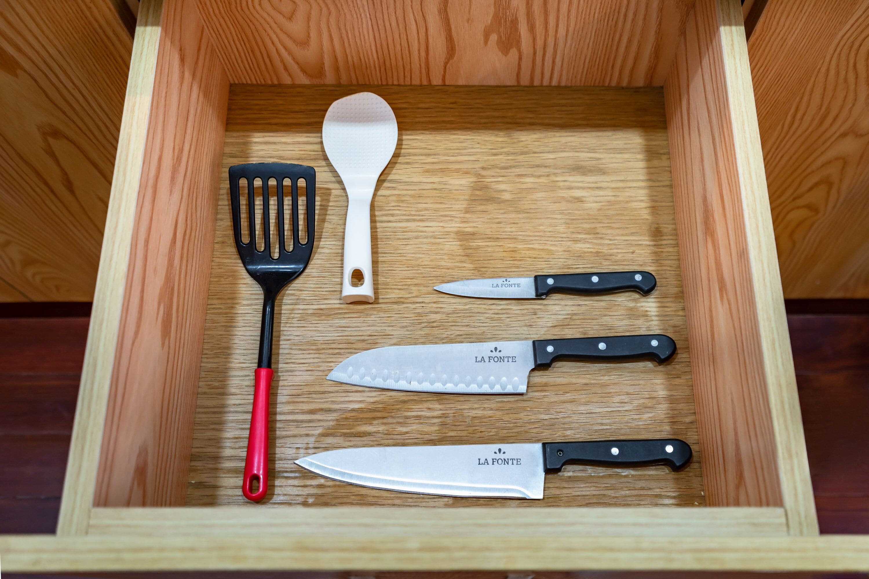 Un tiroir contenant une spatule, un couteau et une cuillère.
