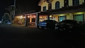 A two-story building with a covered patio area and a car parked in front. - Casa Marcosa Hotel (Tagaytay)