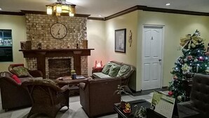 A cozy living room with a fireplace, a Christmas tree, and a door marked 'A'. - Casa Marcosa Hotel (Tagaytay)
