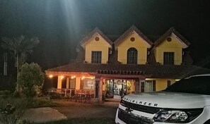 A two-story building with a dining area and a car parked in front. - Casa Marcosa Hotel (Tagaytay)