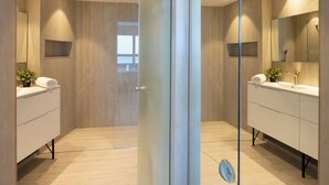 A modern bathroom with a glass partition, two sinks, and a mirror. - Mediterranean Sea Views | 1BR Apt with Balcony (Tel Aviv-Yafo)