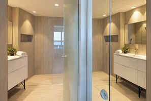 A modern bathroom with a glass partition, two sinks, and a mirror. - Mediterranean Sea Views | 1BR Apt with Balcony (Tel Aviv-Yafo)