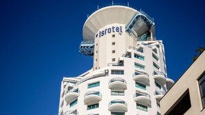 Un grand hôtel à la forme cylindrique, doté de balcons et d’une enseigne indiquant « SEA TOWER Isotel Design ».