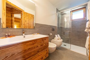 A modern bathroom with a wooden vanity, a large mirror, and a glass shower enclosure. - Marlies Ski in - Ski out 50m, Livigno, Italy (Livigno)