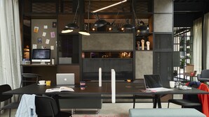 Un espace de bureau moderne comprenant un grand bureau, plusieurs chaises, un ordinateur portable et une bibliothèque.