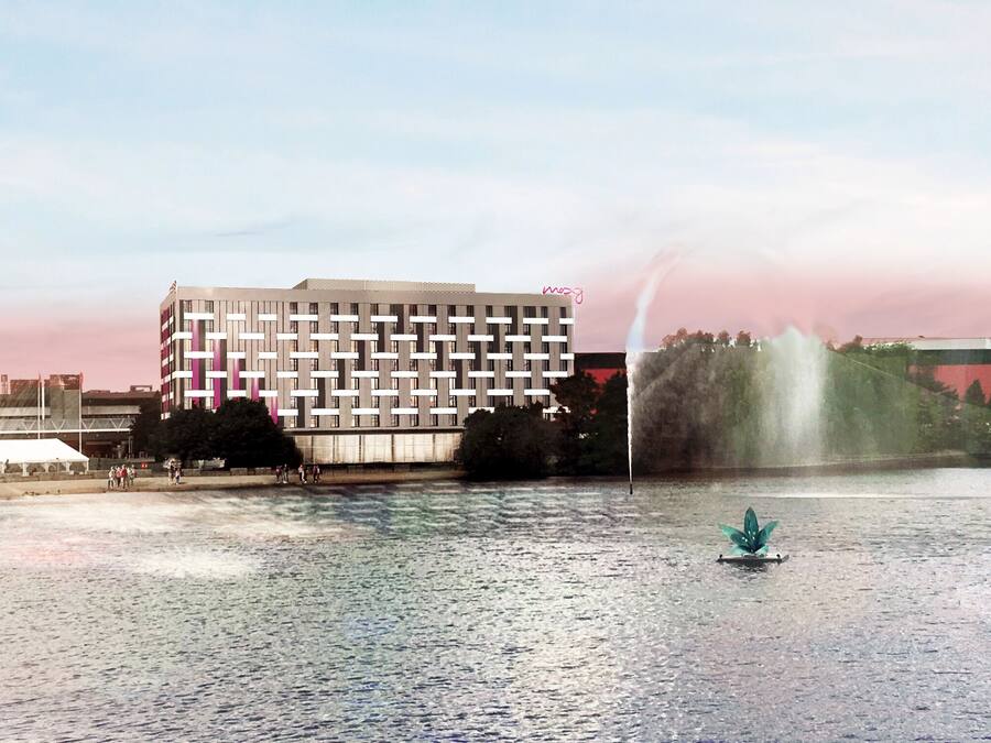 Uitzicht op de rivier met een modern gebouw, een fontein en een klein bootje.