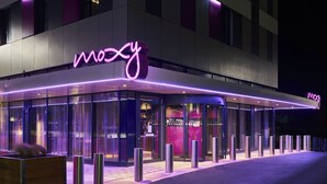 Un bâtiment moderne avec une enseigne au néon indiquant le mot « mozy » et une façade en verre.