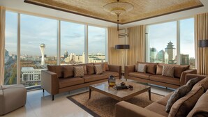 Un salón amplio con ventanas grandes, una lámpara moderna y vistas a la ciudad.