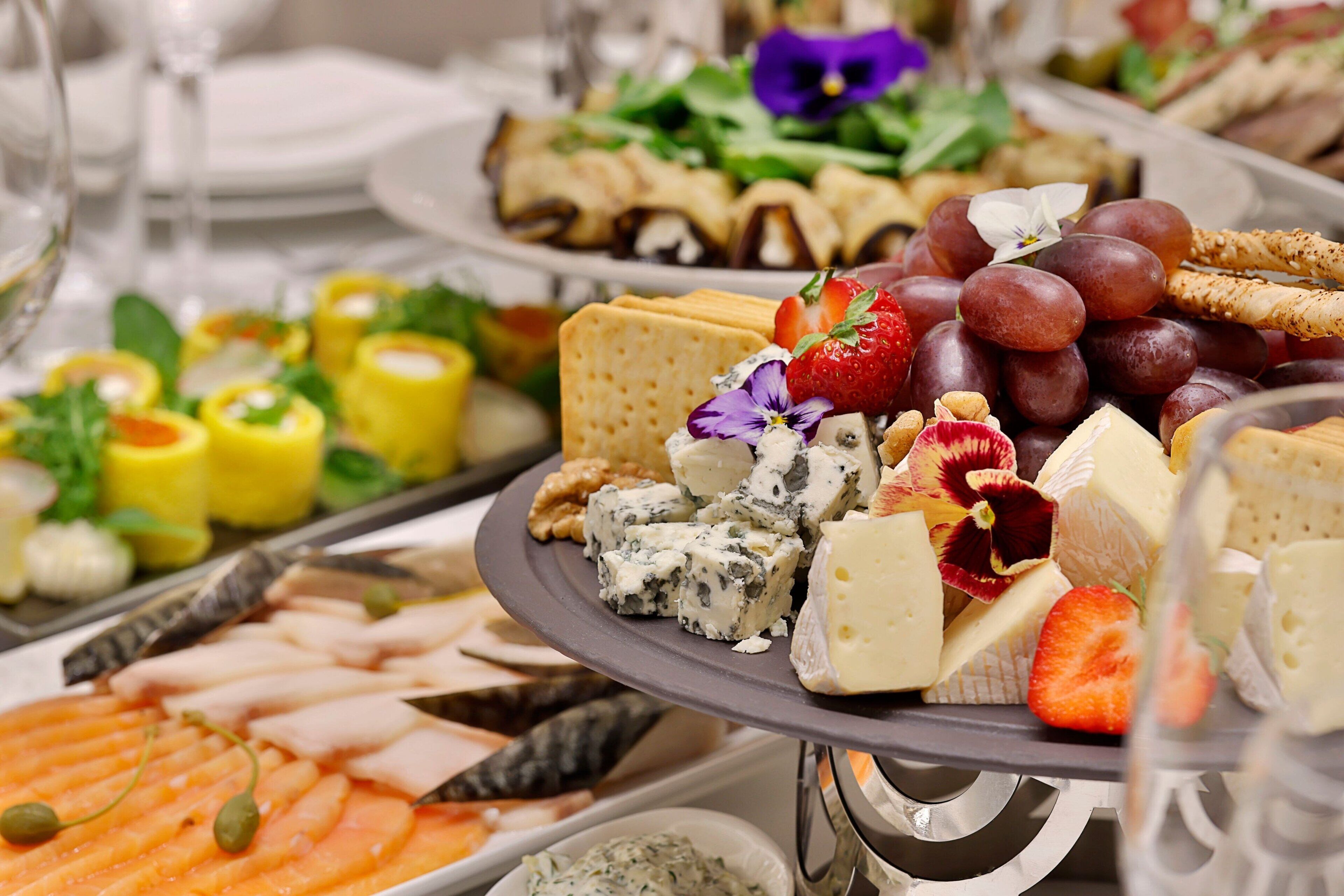 Eine Auswahl an Käse, Obst und Crackern auf einer Platte.