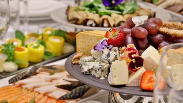 Eine Auswahl an Käse, Obst und Crackern auf einer Platte.