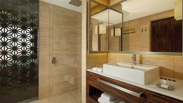 A modern bathroom with a large mirror, a white sink, and wooden cabinetry.