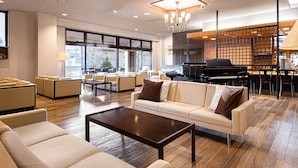 A spacious lobby with a seating area, a piano, and a bar. - The Gran Resort Elegante Karuizawa (Karuizawa)