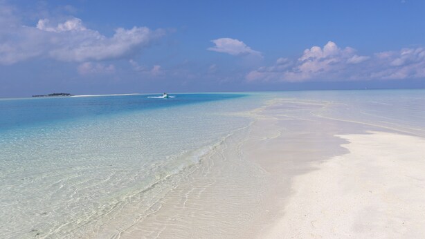 A beach with clear turquoise water and white sand. - Rasdhoo Wave Blue (Rasdhoo)
