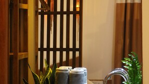 A bathroom with a wooden vanity, a sink, a mirror, a towel rack, and a potted plant. - Rasdhoo Wave Blue (Rasdhoo)